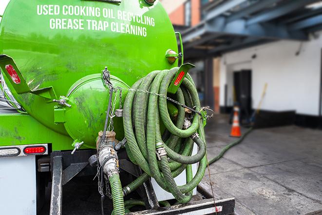 a technician pumping a grease trap in a commercial building in Cameron Park